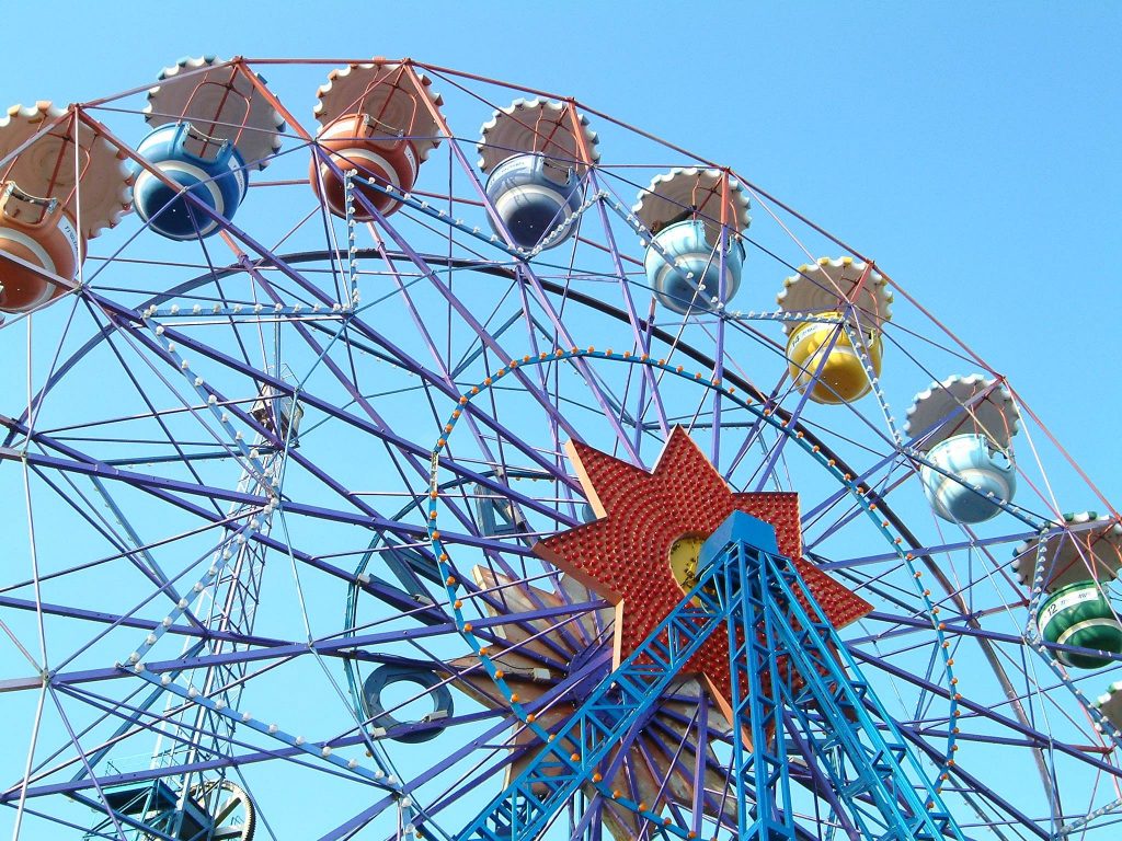 גלגל ענק וצבעוני בלונה פארק על רקע שמיים כחולים ובהירים