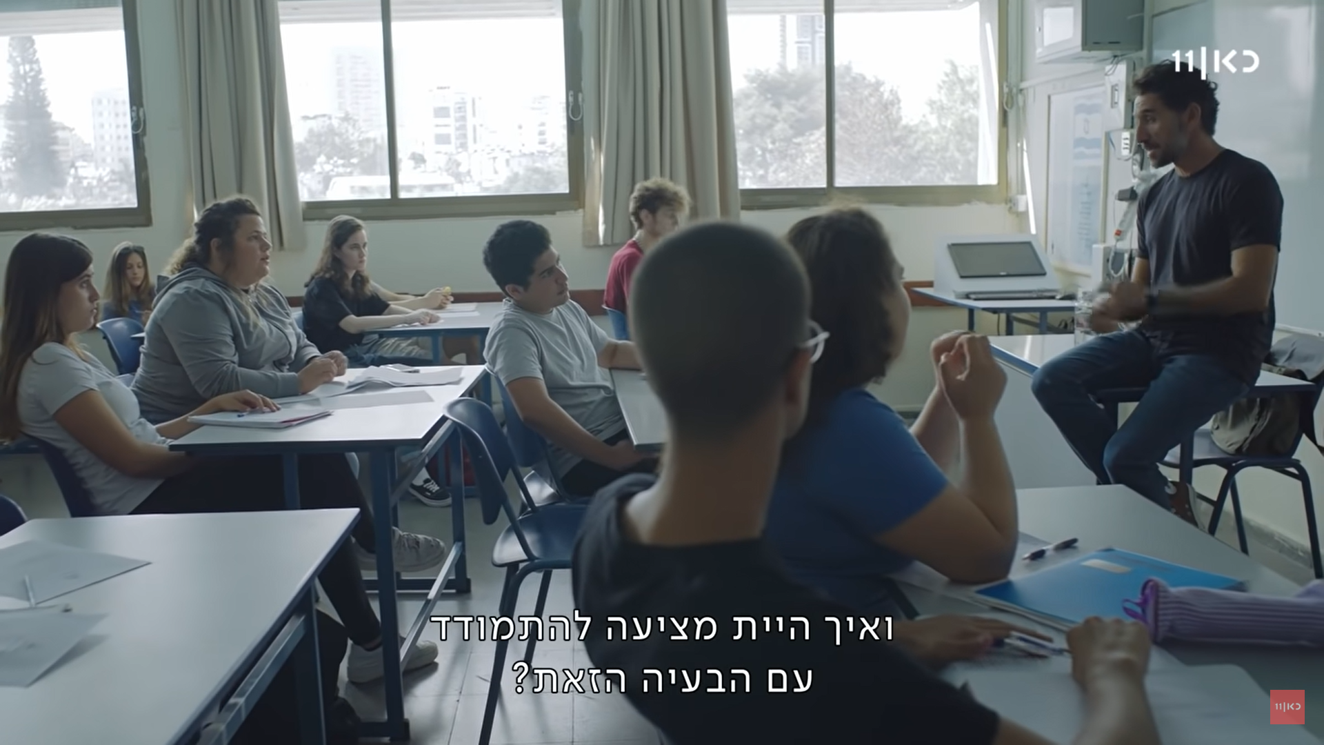 בשיעור אזרחות, המורה אמיר (דורון בן דוד) מלמד את התלמידים ויושב בקצה השולחן. ממולו יושבת התלמידה ליאן (מיה לנדסמן)