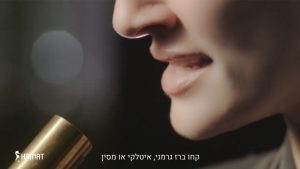 תמונה מתוך הפרסומת של חמת, השפתיים של רונה לי שמעון פשוקות ומול קצה של ברז