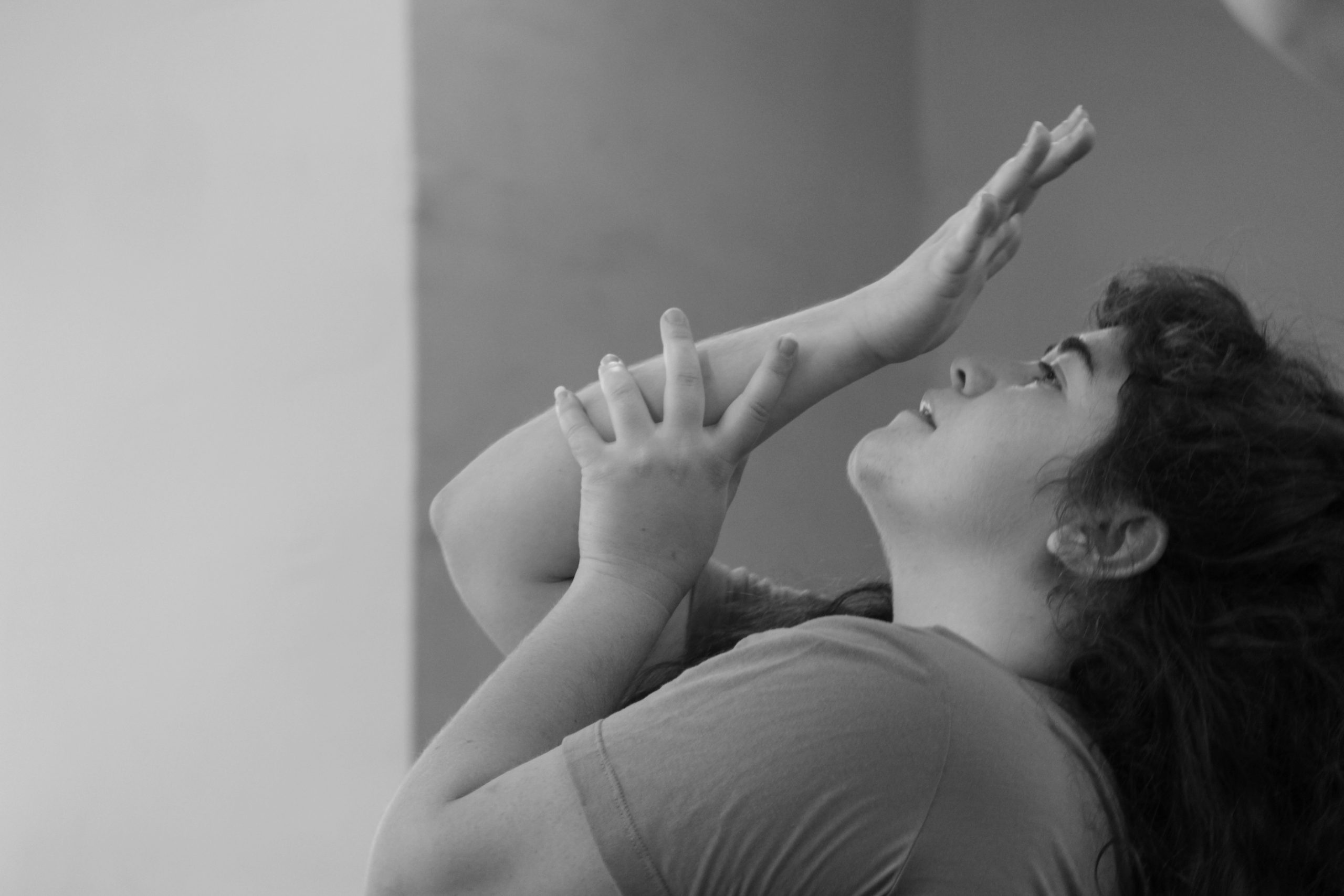 תמונת דיוקן פרופיל בשחור לבן: מישהי מניחה יד על יד מעל פניה.