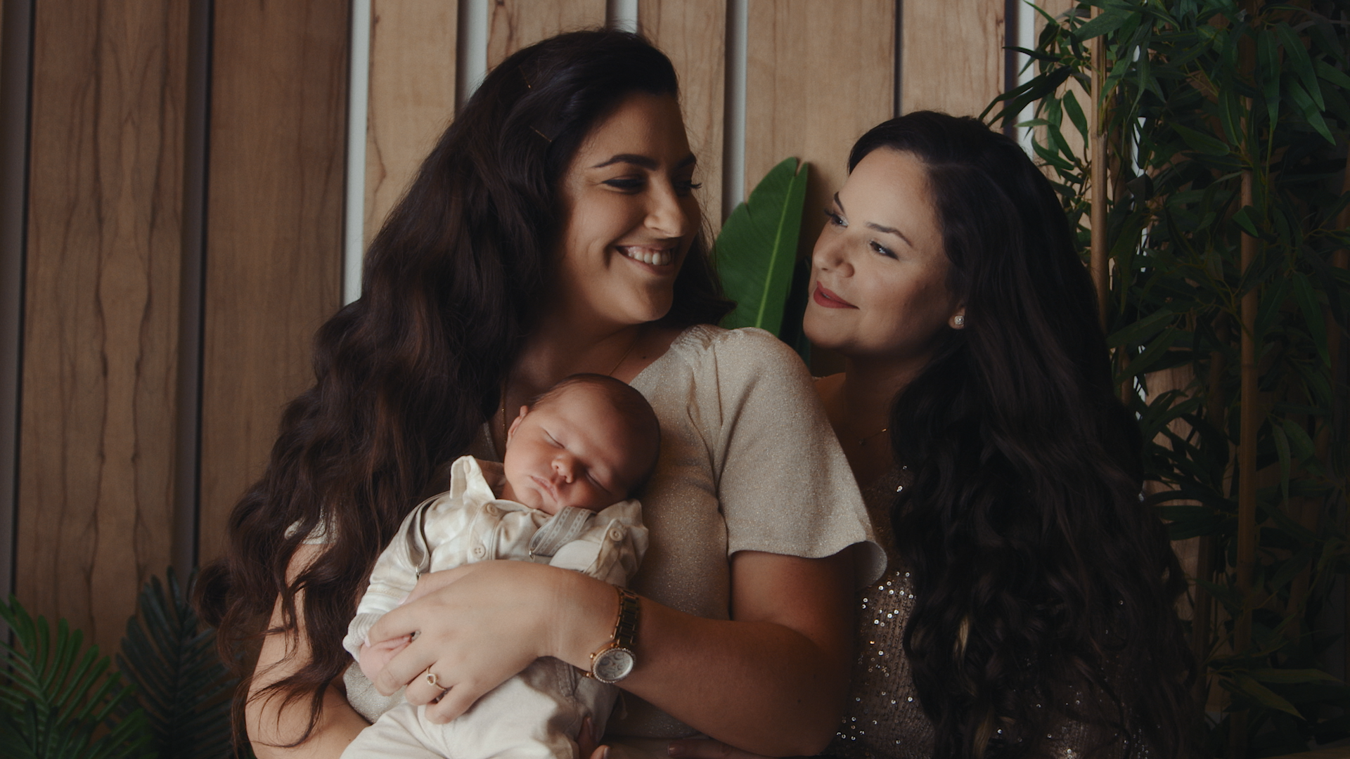 שתי נשים מחזיקות תינוק ומחייכות