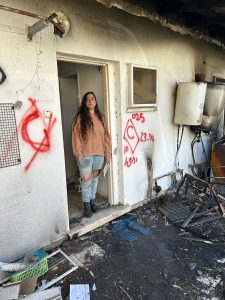 הגר בביתה בניר עוז אחרי ה7/10. הבית הפוך ושרוף, דברים שבורים, והגר עומדת במרכזו.